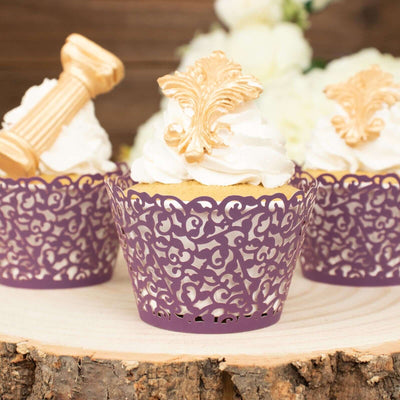 Purple cupcake wrappers with ornate designs and golden decorations on top.