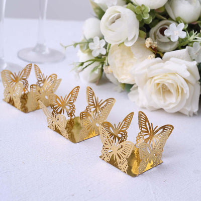 Gold butterfly-shaped candle holders arranged with floral decor.