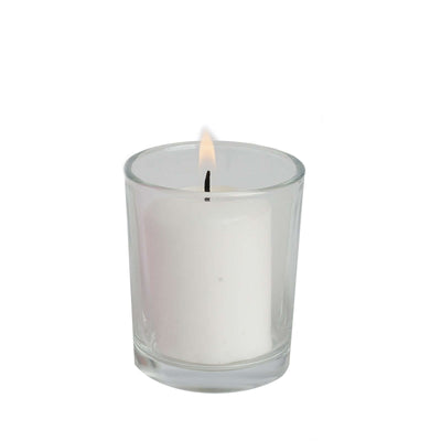 White candle in glass jar with flame