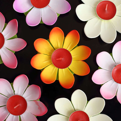 Colorful flower-shaped candles arranged artistically on a dark background.