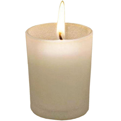 White candle with a flickering flame in a glass holder