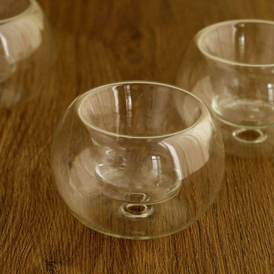 Clear glass candle holder with unique shape and design.