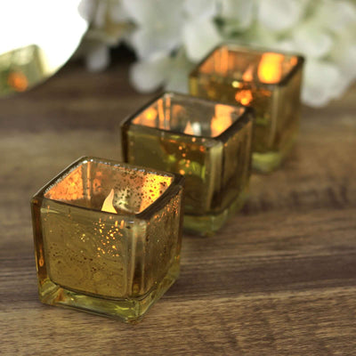Set of three decorative amber glass candle holders glowing softly.