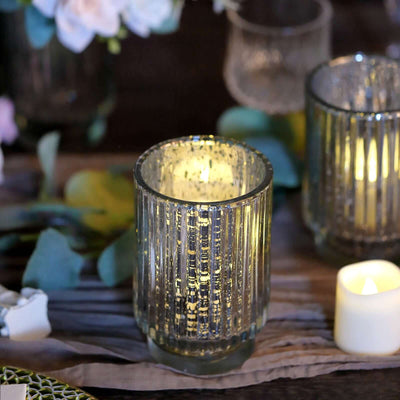 Decorative glass candle holder with candlelight reflecting off textured surface.