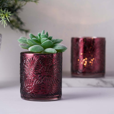 Decorative maroon candle holder with succulent plant