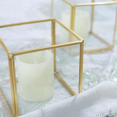 Candle in a decorative glass holder on a textured white surface.
