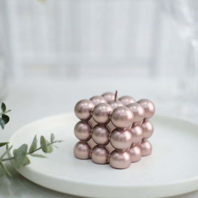 Rose gold decorative candle in a unique geometric shape.