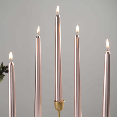 Pink taper candles lit in a stylish candle holder.