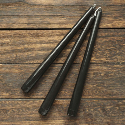 Black gel pens arranged on a wooden surface.