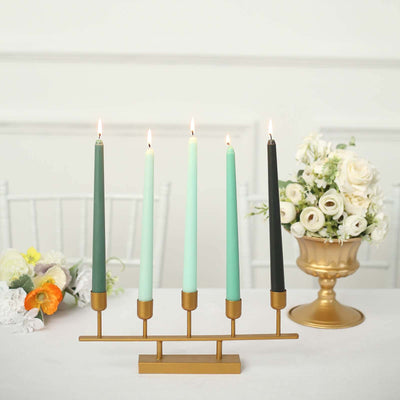 Elegant candle holder with five colorful candles and floral arrangement.