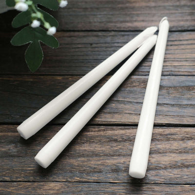 White decorative candles on wooden surface.