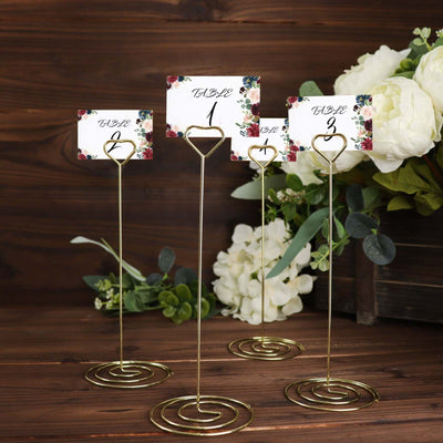Gold table number holders with floral cards for events and weddings.