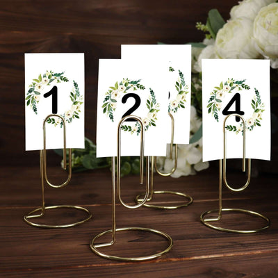 Gold table number holders with floral wreath designs, numbers 1 to 4.