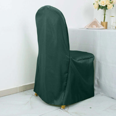 Green chair cover on a dining chair near a table with flowers.