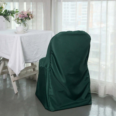 Green chair cover on a dining chair next to a table with a floral centerpiece.