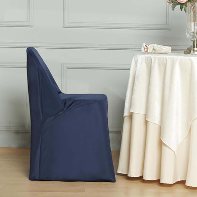 Navy blue chair cover draped on a chair beside an elegant table setting.