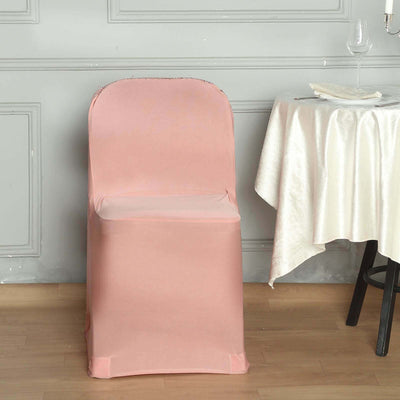 Pink chair cover draped over a chair beside a table with a wine glass.
