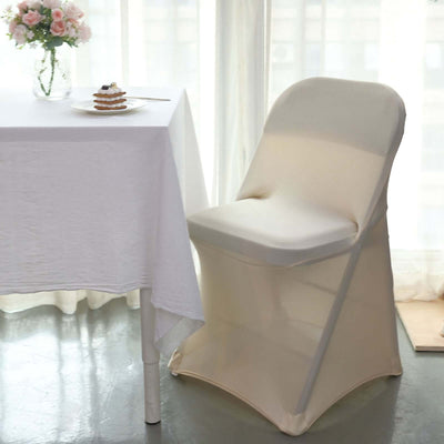 Elegant folding chair with cream cover beside a table set for tea.