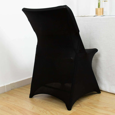 Black folding chair cover on a wooden floor, styled for an elegant dining setup.
