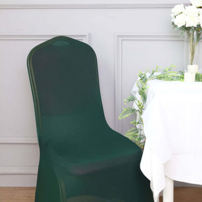 Green chair cover on a dining chair near a table with flowers and decor.