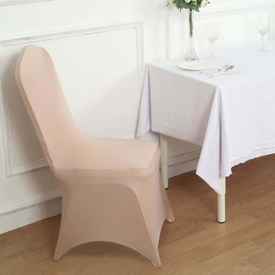 Beige chair cover on a dining chair beside a table set for a meal.