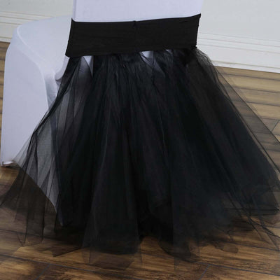 Black tulle chair cover with flowing skirt for elegant event decor.