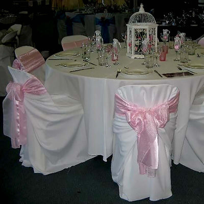 Elegant table setting with pink sashes and decorative centerpiece