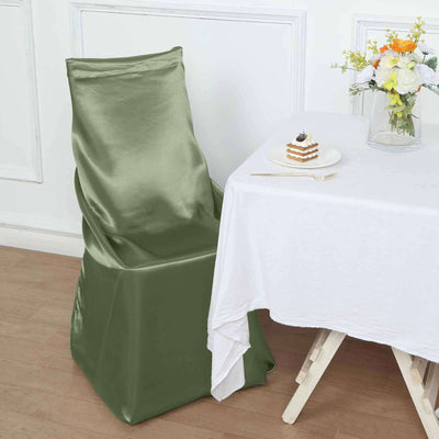 Green satin chair cover draped on a chair beside a table with dessert.