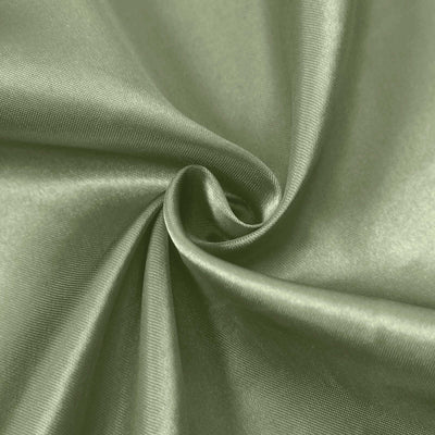 Soft green satin fabric swirl texture close-up.