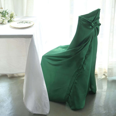 Green satin chair cover draped elegantly over a chair in a dining setting.