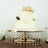 Elegant two-tiered cake with gold crown and decorative accents on a stand.
