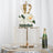 Elegant crown cake with floral accents on a crystal stand, champagne, and glasses.