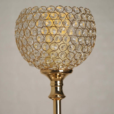 Elegant gold floor lamp with crystal beaded shade illuminating a warm glow.