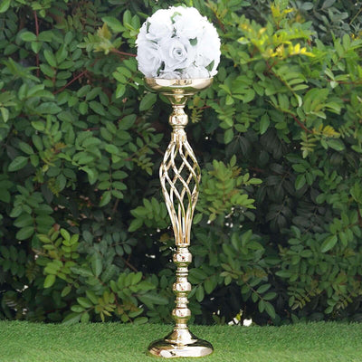 Gold flower stand with white roses, set against greenery.