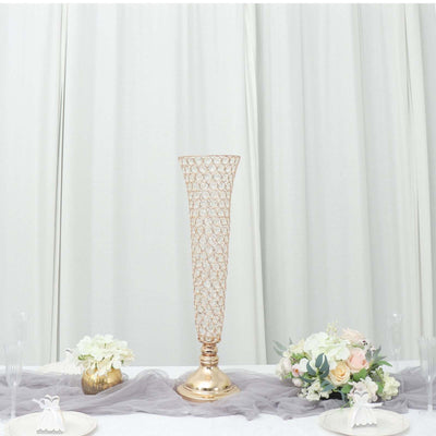 Elegant rose gold wire vase centerpiece on a table with floral arrangements.