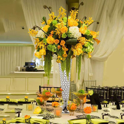 Elegant floral arrangement in a tall vase, featuring yellow and orange blooms.