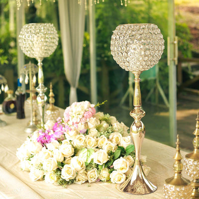 Elegant crystal candle holders on a table with roses and flowers.
