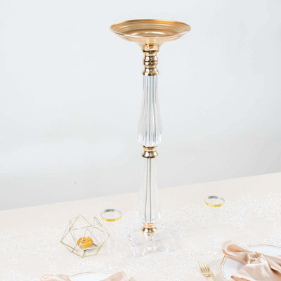 Elegant gold and clear glass candle holder on a white backdrop.