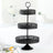 Black three-tiered serving stand with intricate cutout design.