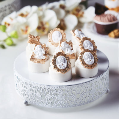 Elegant decorative desserts on a white cake stand with floral accents.