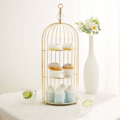 Gold cupcake stand with assorted cupcakes and a vase of flowers
