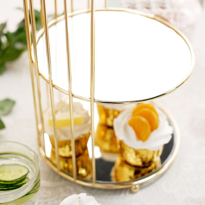 Gold-tiered dessert stand with cupcakes and decorative fruit.