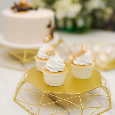 Mini cupcakes with whipped cream on a gold geometric platter, elegant dessert display.