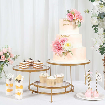 Elegant wedding cake with cupcakes and desserts on decorative stands.