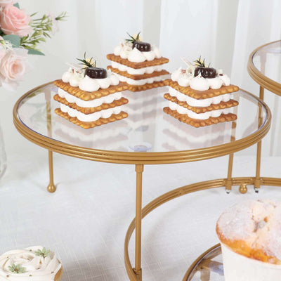 Layered dessert on a glass stand with gold accents and floral backdrop.