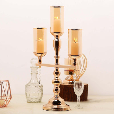 Elegant three-arm candle holder with glass shades and a polished finish.