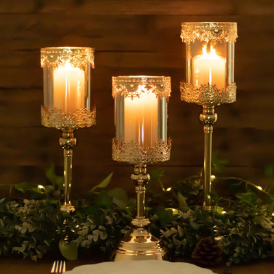 Elegant gold candle holders with lace accents, glowing candles, and greenery decor.