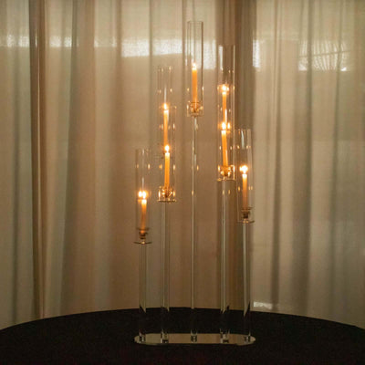 Elegant candle holder with multiple glass tubes and lit candles.