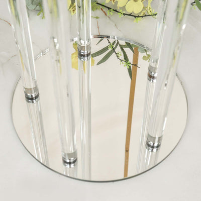 Reflective glass table with clear acrylic legs and floral arrangement.