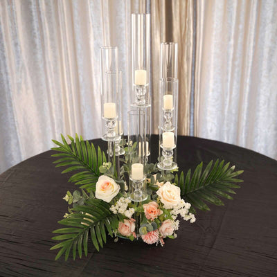 Elegant candle holder centerpiece with flowers and greenery.